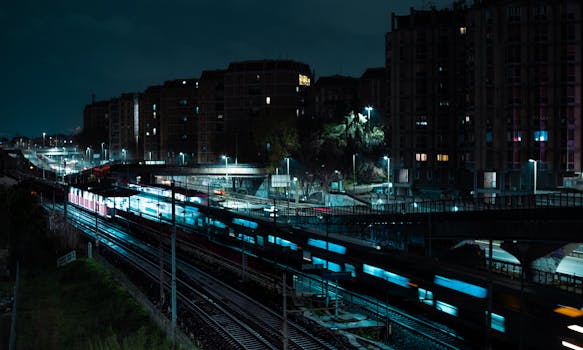 Night cityscape featuring motion blur of trains, highlighting urban dynamic life.