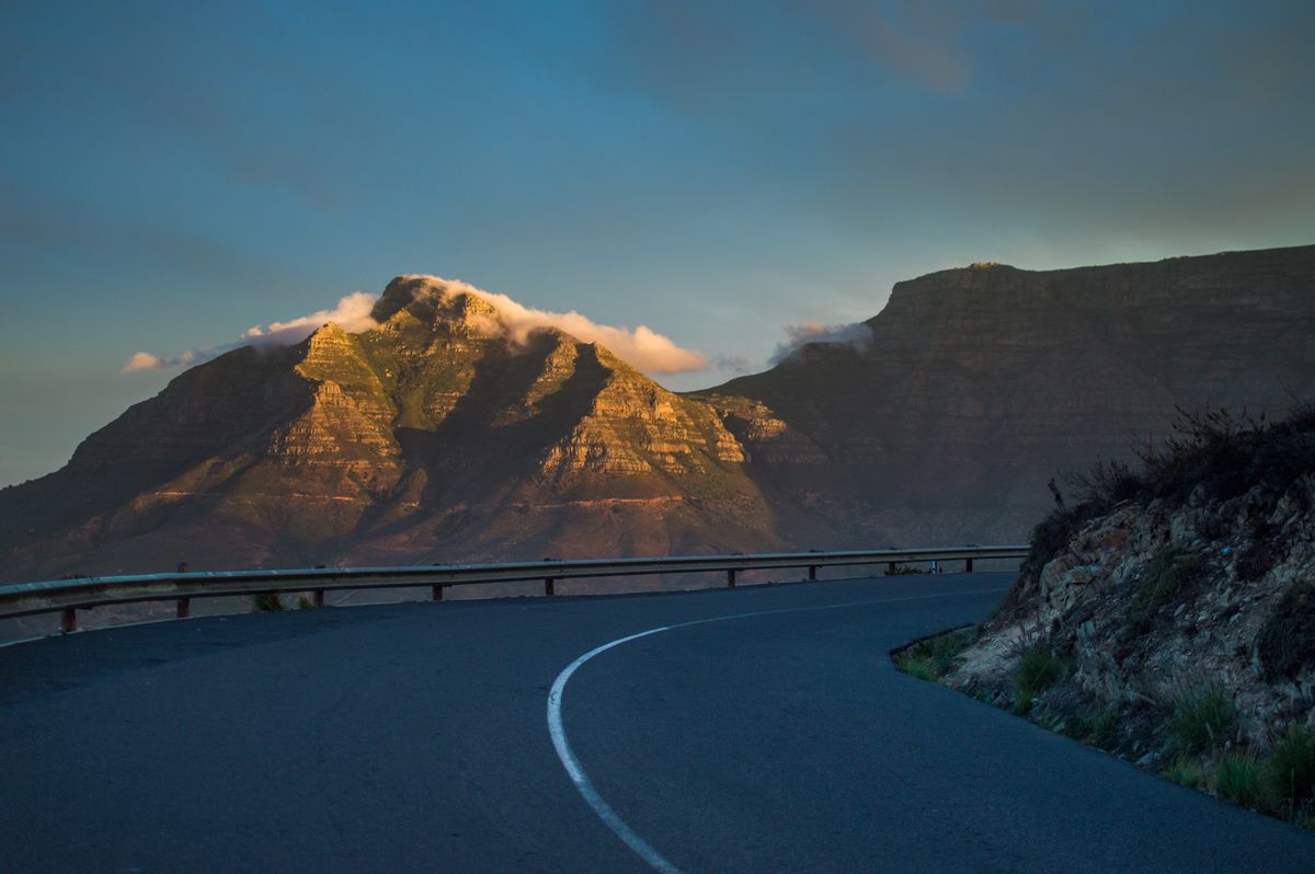 A curving mountain pass road at dusk — photo by Shay Wood on Pexels