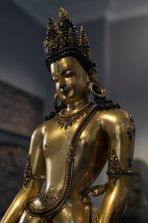 A gold statue of buddha in a museum