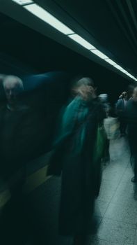Blurred people in motion at an underground subway station, capturing dynamic urban life.