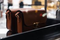 Stylish brown leather handbags showcased indoors with soft focus lights.