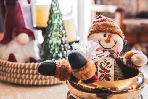 A Snowman Plush Toy on Gold Ceramic Bowl