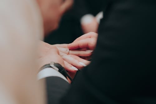 Person Putting on a Wedding Ring on a Woman's Finger