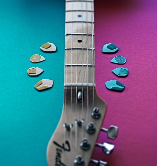 Free Electric guitar neck with colorful picks on vibrant background, showcasing music tools. Stock Photo