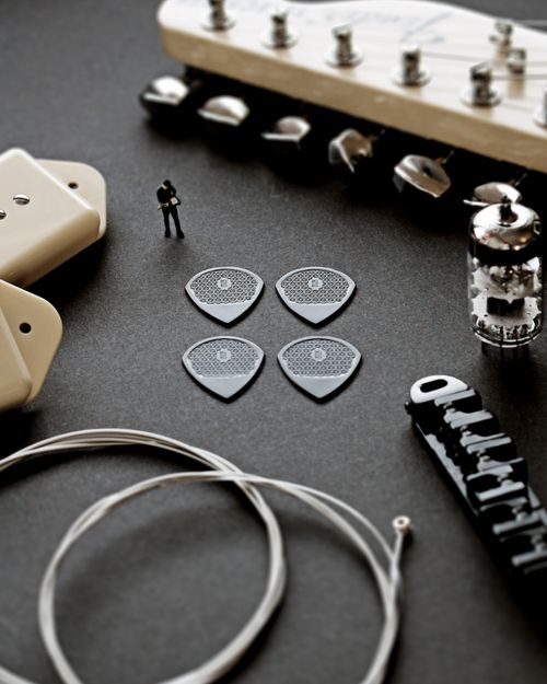 Free Close-up of electric guitar accessories including picks, strings, and parts on a dark surface. Stock Photo