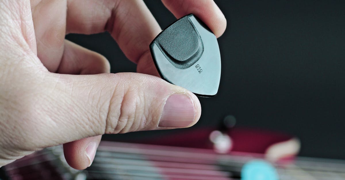 Hand Holding Guitar Pick · Free Stock Photo