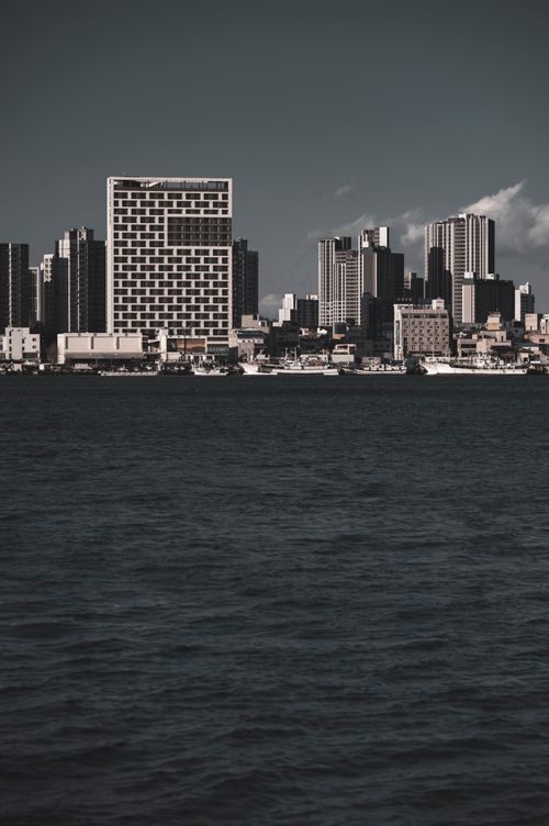 Free A captivating city skyline viewed from across the ocean with modern architecture. Stock Photo