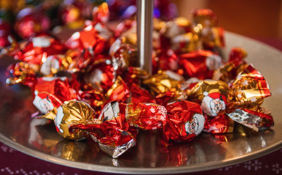 Close-up of colorful wrapped chocolates on a tray, perfect for Christmas celebrations.
