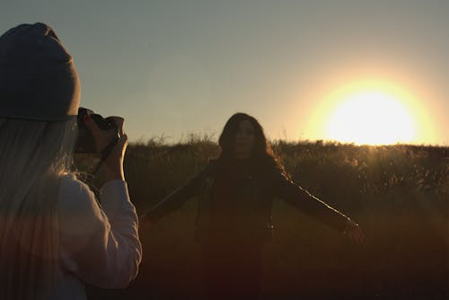 Person Taking Photo of Another Person during Sunset