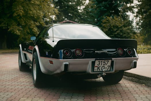 Classic black Chevrolet Corvette parked on a paved lot in Minsk, Belarus.