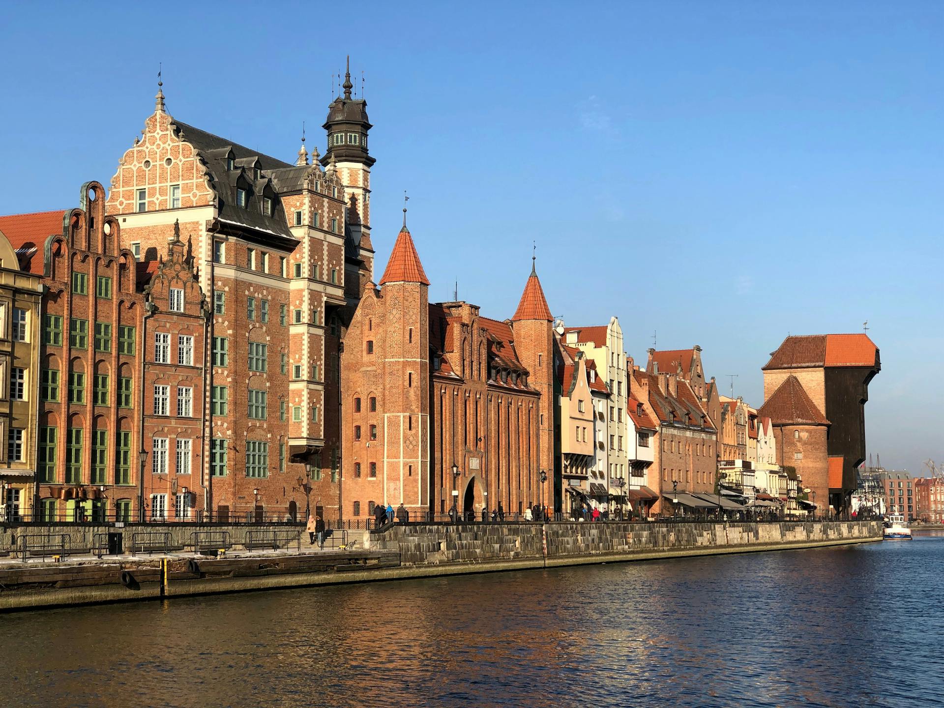 Een schilderachtig uitzicht op de historische waterkant van Gdańsk met gotische architectuur.