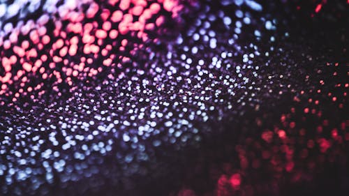 A close up of a black and red background with water droplets