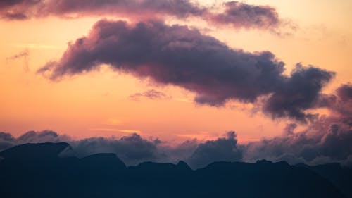 Silhouetted Mountains under a Dramatic Sunset Sky 