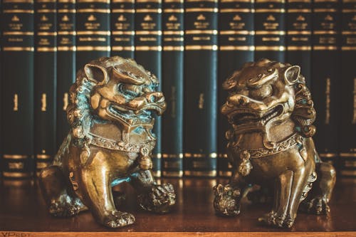 две фигурки коричневых китайских львов хранителей на столе