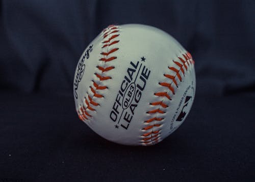 White and Orange Official League Baseball on Black Textile