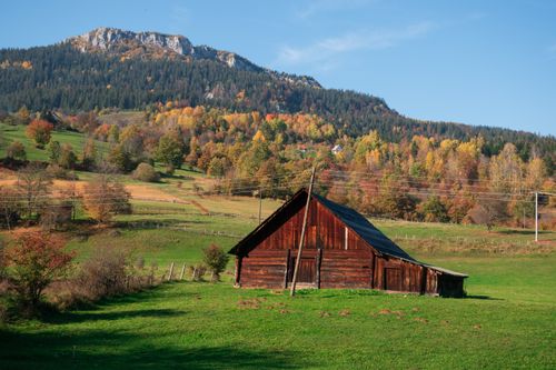 Free Capture the essence of autumn in Podgrab's serene rural setting with a classic wooden barn. Stock Photo