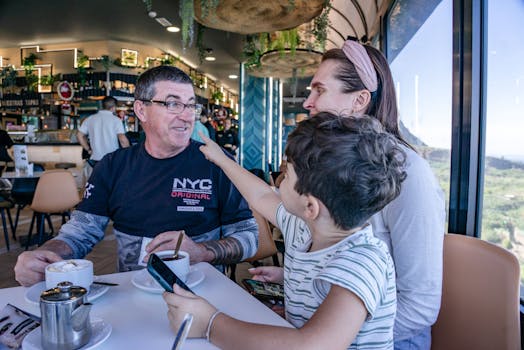 Family sitting at a cafe table enjoying coffee and having a lively conversation.