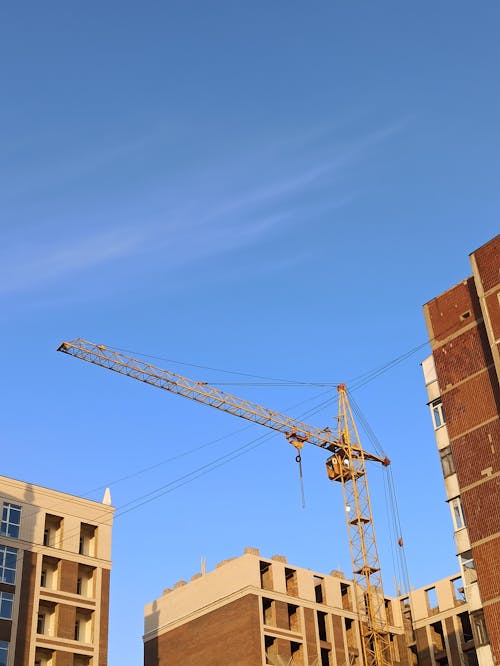 Foto profissional grátis de céu azul, edifícios de concreto, grua