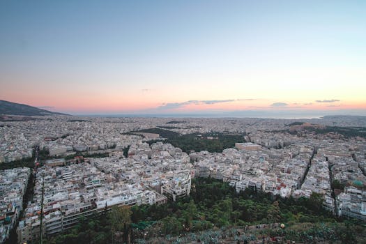 Stunning aerial cityscape of Athens, Greece, captured at sunset highlighting urban architecture and distant skyline.