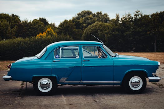 Classic blue Gaz 21 car parked outdoors in Minsk, Belarus during summer.