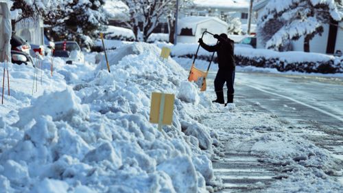 Free A person clearing heavy snow from a city street after a winter storm, emphasizing urban winter challenges. Stock Photo