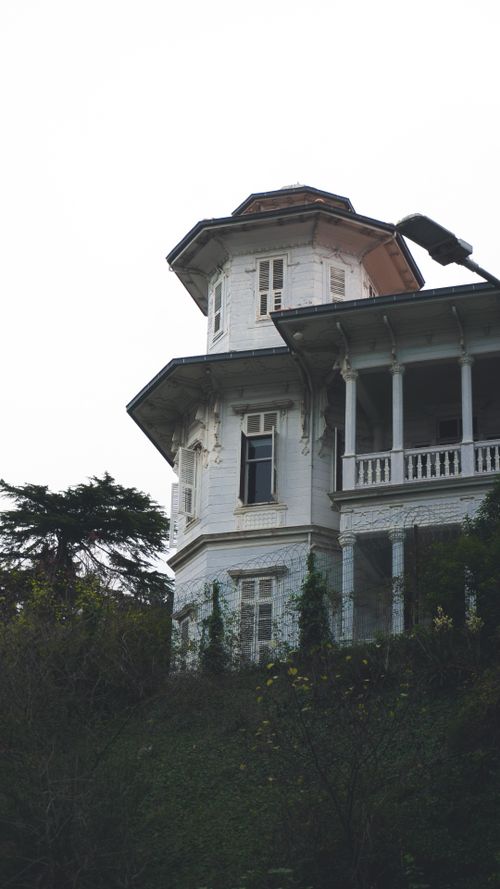 Free Charming Victorian architecture featuring a white facade with intricate details and a wraparound balcony. Stock Photo
