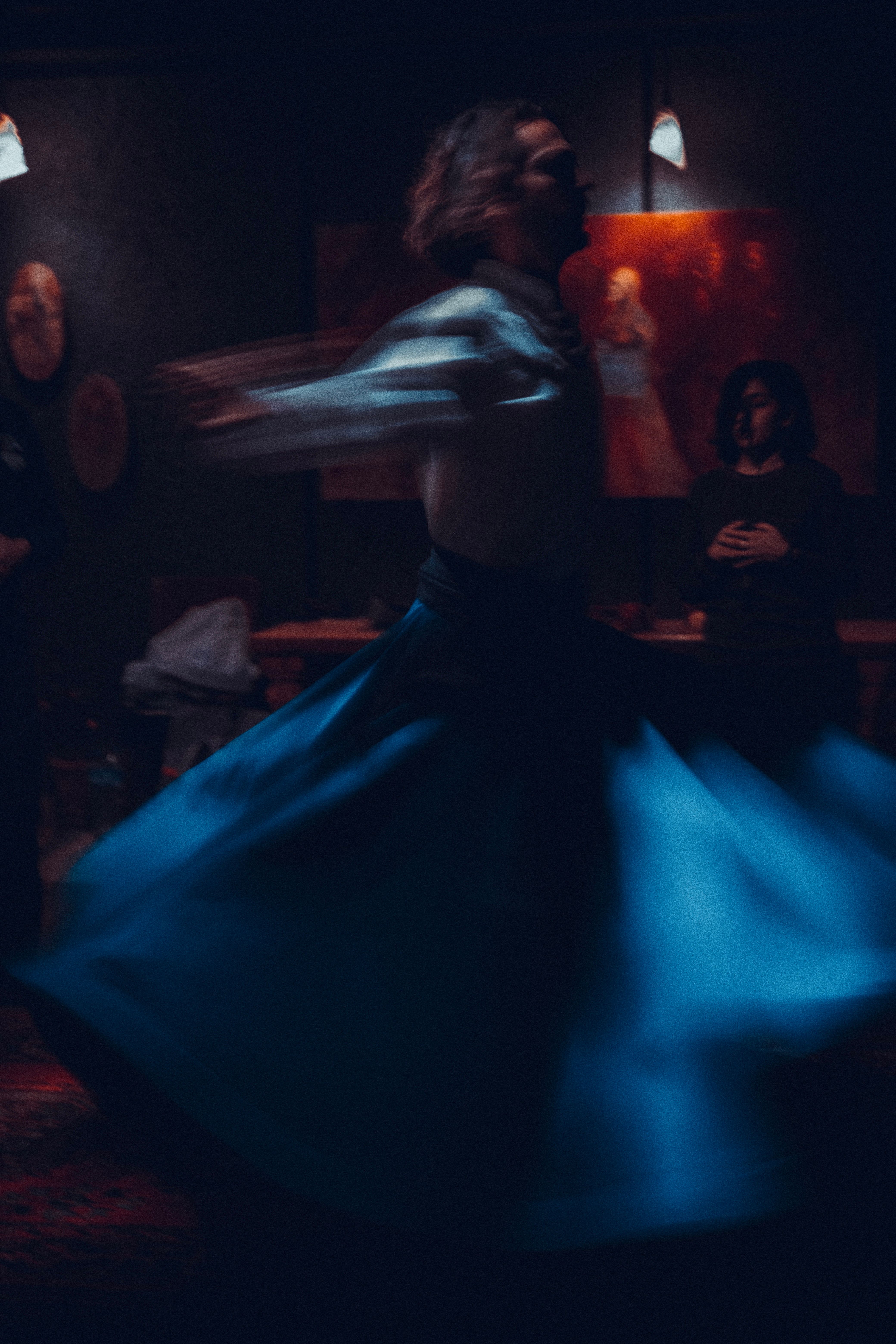 Blurred motion shot of a dancer spinning indoors, creating an artistic and dramatic effect.