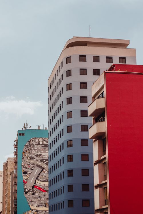 Free A modern cityscape showing tall buildings with vibrant murals in a clear sky setting. Stock Photo