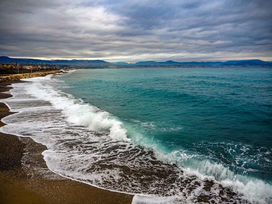 Fotomural Explora la serena vista costera de Antibes, Francia, con olas azules y cielos nublados.