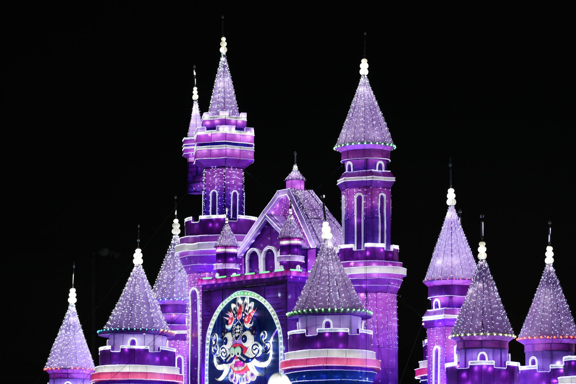 A whimsical purple castle illuminated brightly at night, capturing a sense of fantasy. — free online jigsaw puzzle on JigsawPuzzlesFreeOnline.org