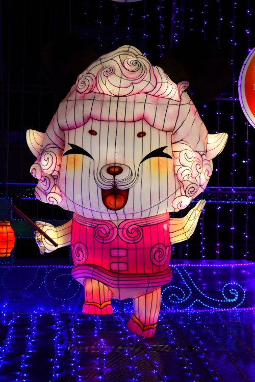 Free Vibrant and whimsical festival lantern shaped like a cheerful figure, illuminated at night. Stock Photo
