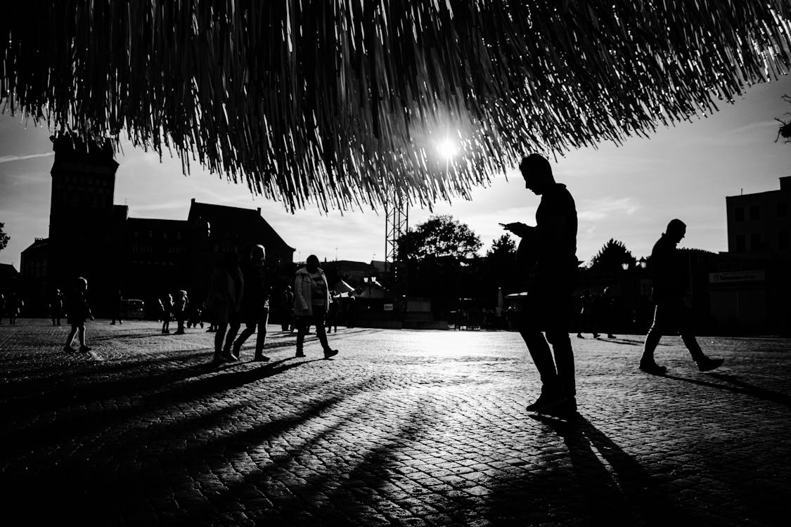 公園を歩く人々のグレースケール写真