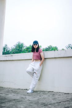 Fashionable woman poses in a crop top and trousers outdoors in Cimahi, Indonesia.