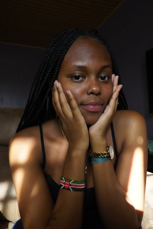 A Woman in Black Tank Top with Her Hands on Her Face