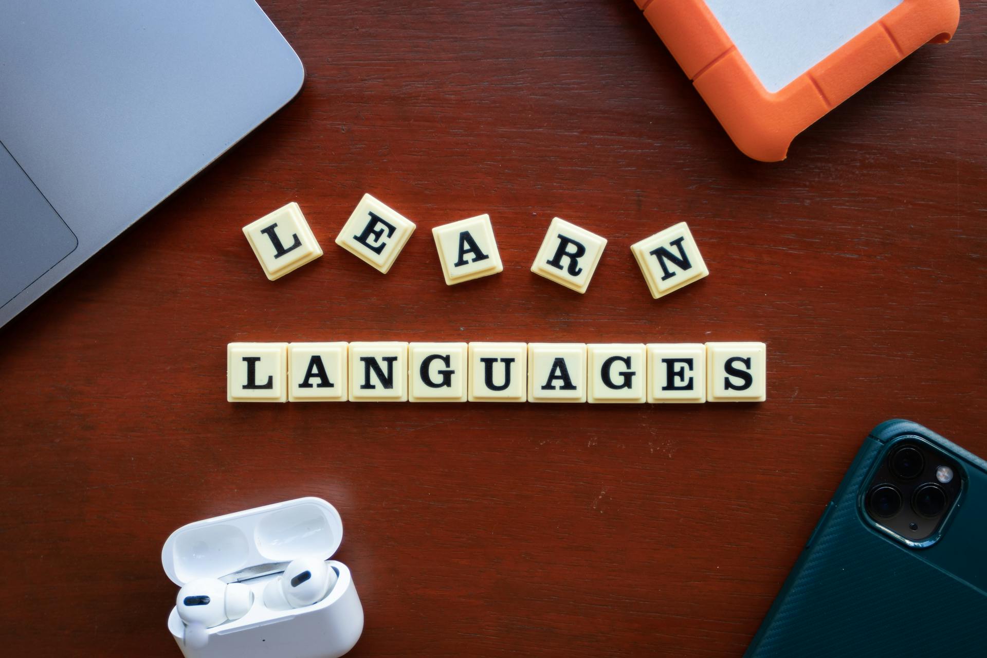 Flat lay of language learning materials with gadgets promoting education.