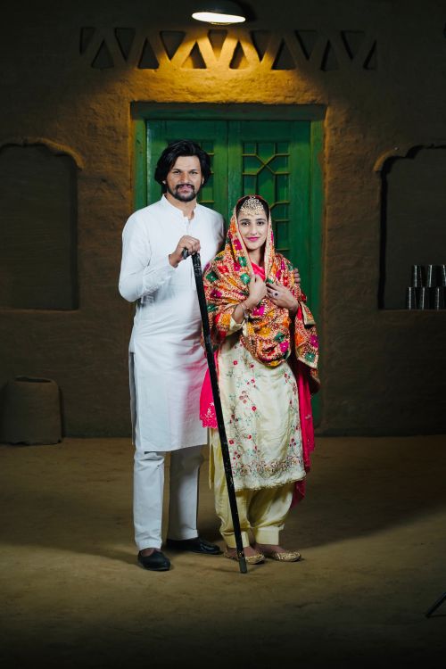 Free A newlywed couple dressed in traditional Indian attire posing indoors in Punjab, India. Stock Photo