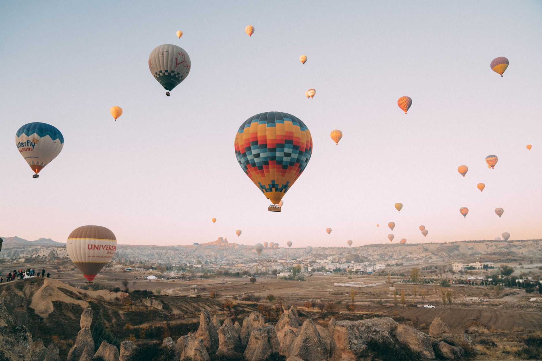 A stunning display of hot air balloons soaring over Cappadocia's unique landscape at dawn.