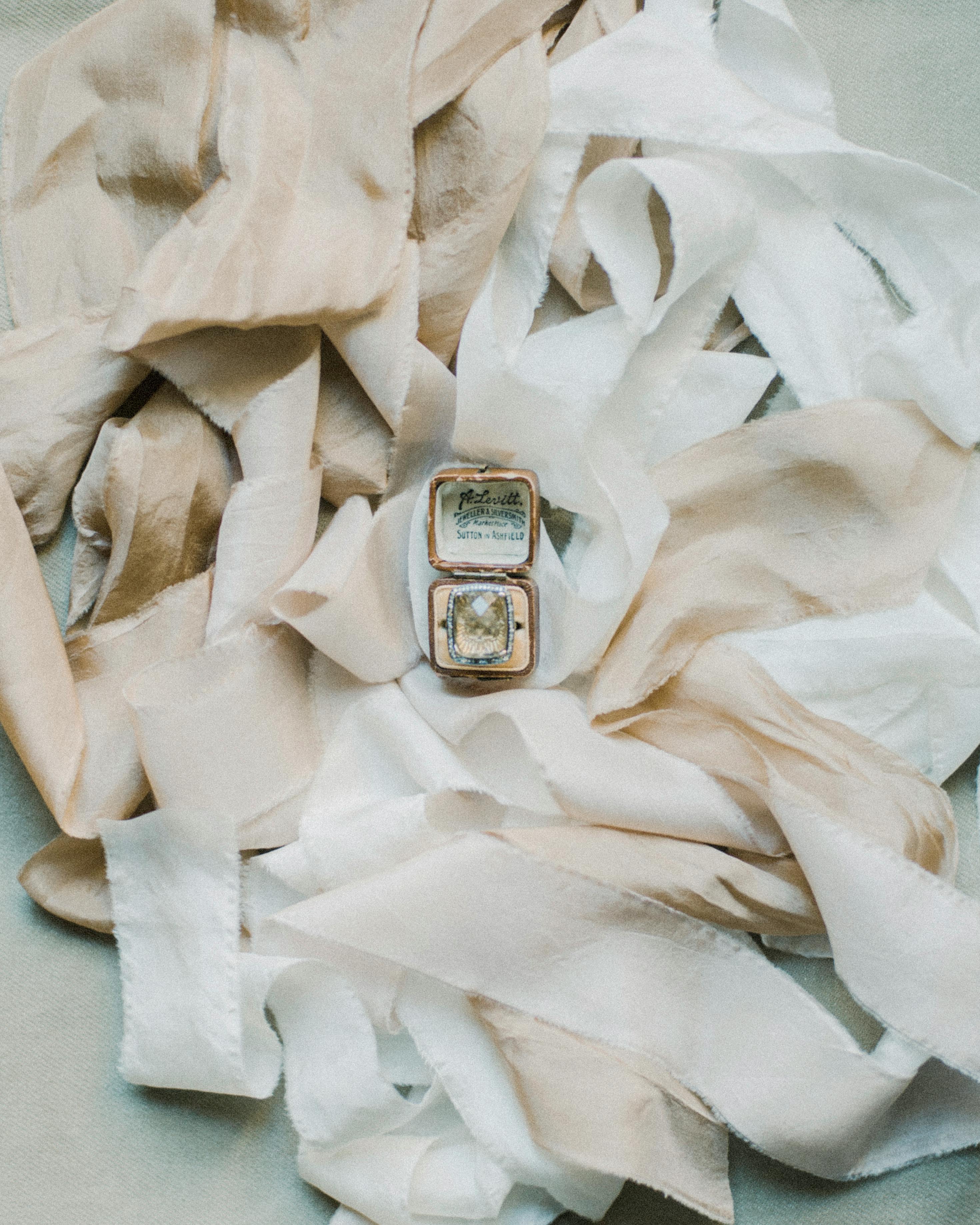 Beautiful vintage jewelry box amidst soft fabric showcases elegance in fashion photography.