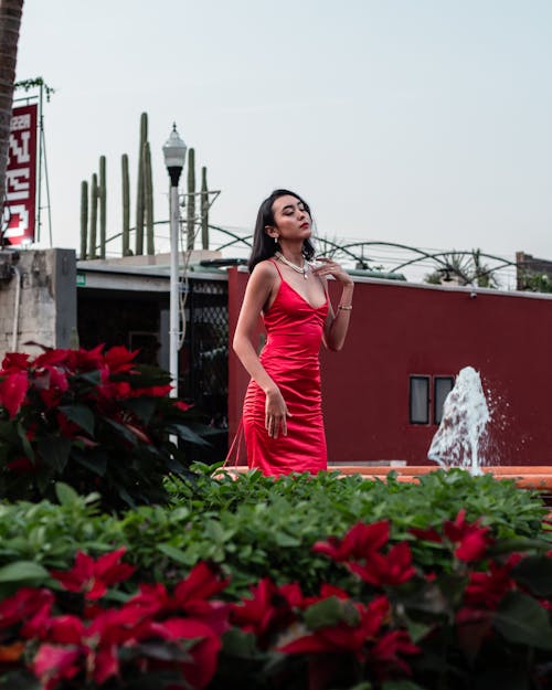 A Woman Wearing Red Dress Standing on the Park