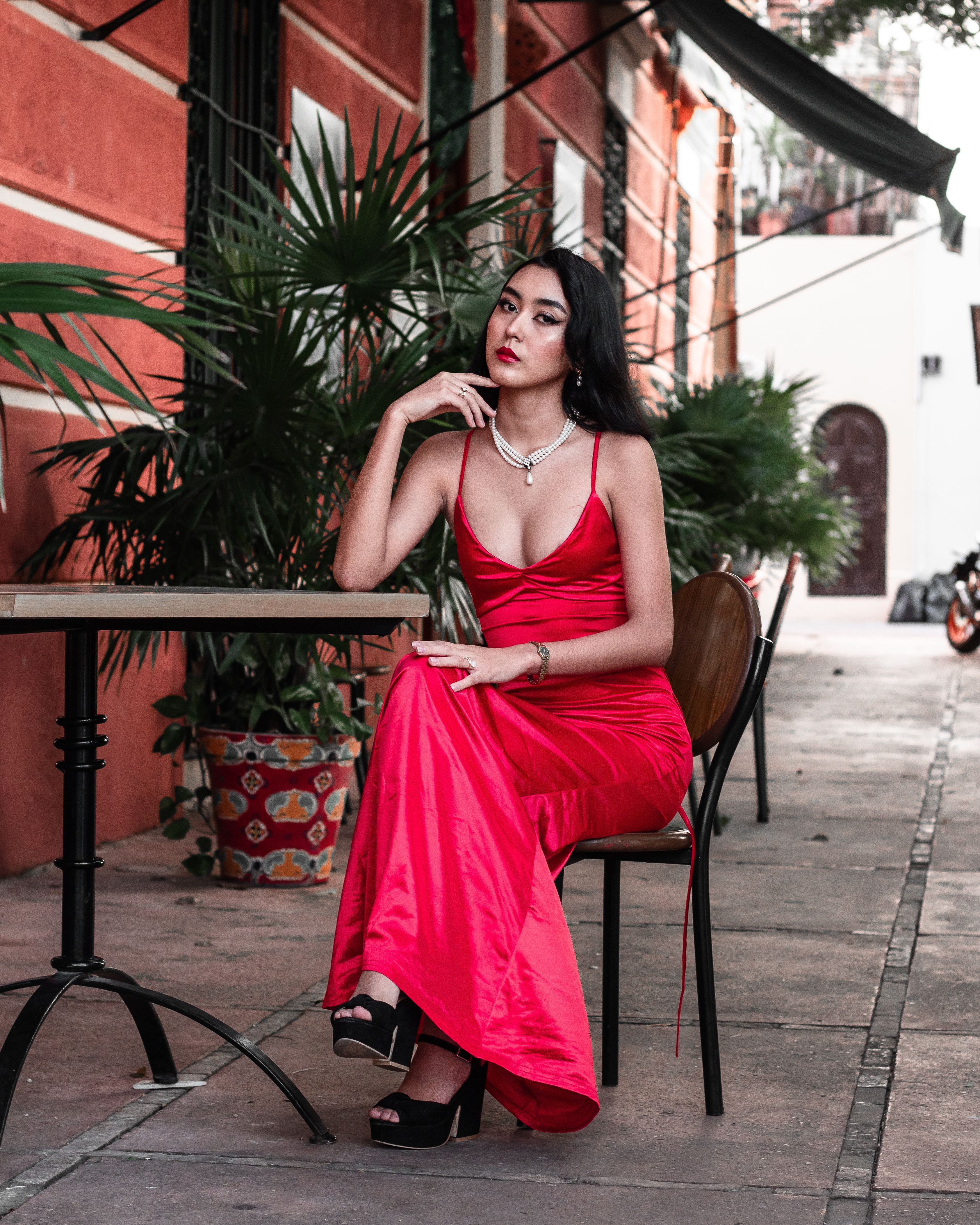 A Woman Wearing a Red Dress Sitting on the Chair · Free Stock Photo