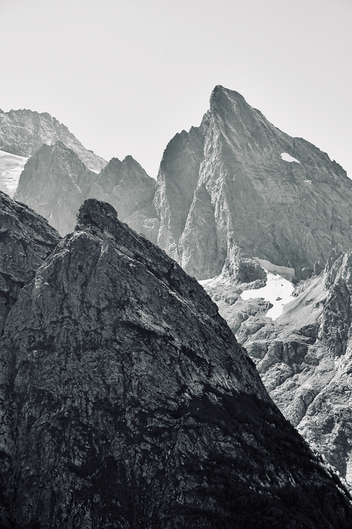 Free Captivating black and white image of towering mountain peaks with snow patches. Stock Photo