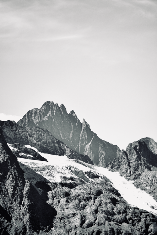 Free Beautiful grayscale photograph of a rugged mountain peak with a glacier. Stock Photo
