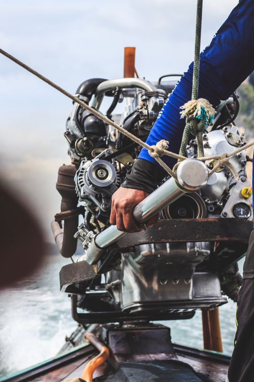 Man Riding Engine Man with a Large Engine in a Workshop · Free Stock Photo