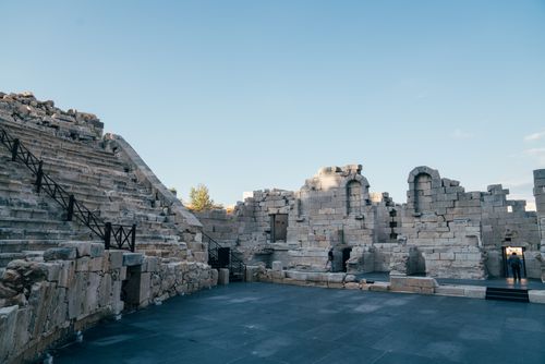 Free Explore the ancient amphitheatre ruins with historic stone seats and stage under a clear sky. Stock Photo