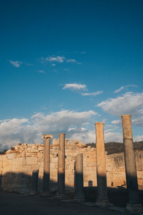 Free Old stone columns and ruins captured under a clear blue sky, embodying history and antiquity. Stock Photo