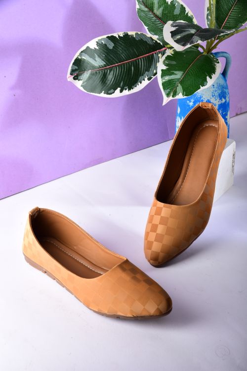 Free Elegant brown checkered sandals displayed on a white surface with green leaves backdrop for aesthetic appeal. Stock Photo