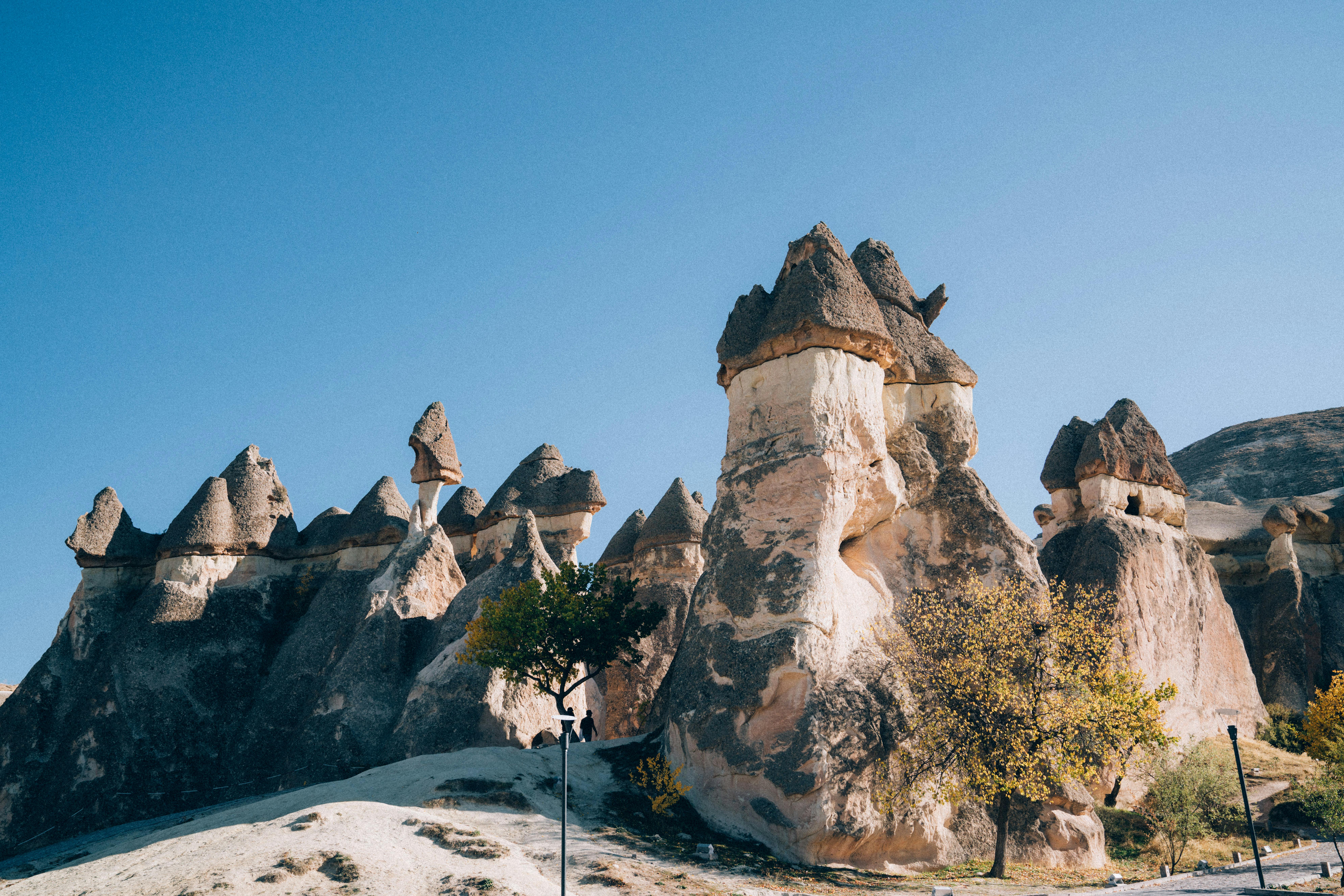 Fairy chimneys Cappadocia at sunrise with volcanic rock formations, golden light, Red Valley Turkey, surreal landscape