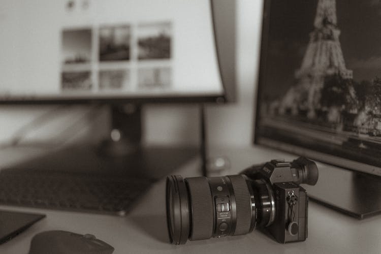 An SLR Camera And A Computer On A Desk 