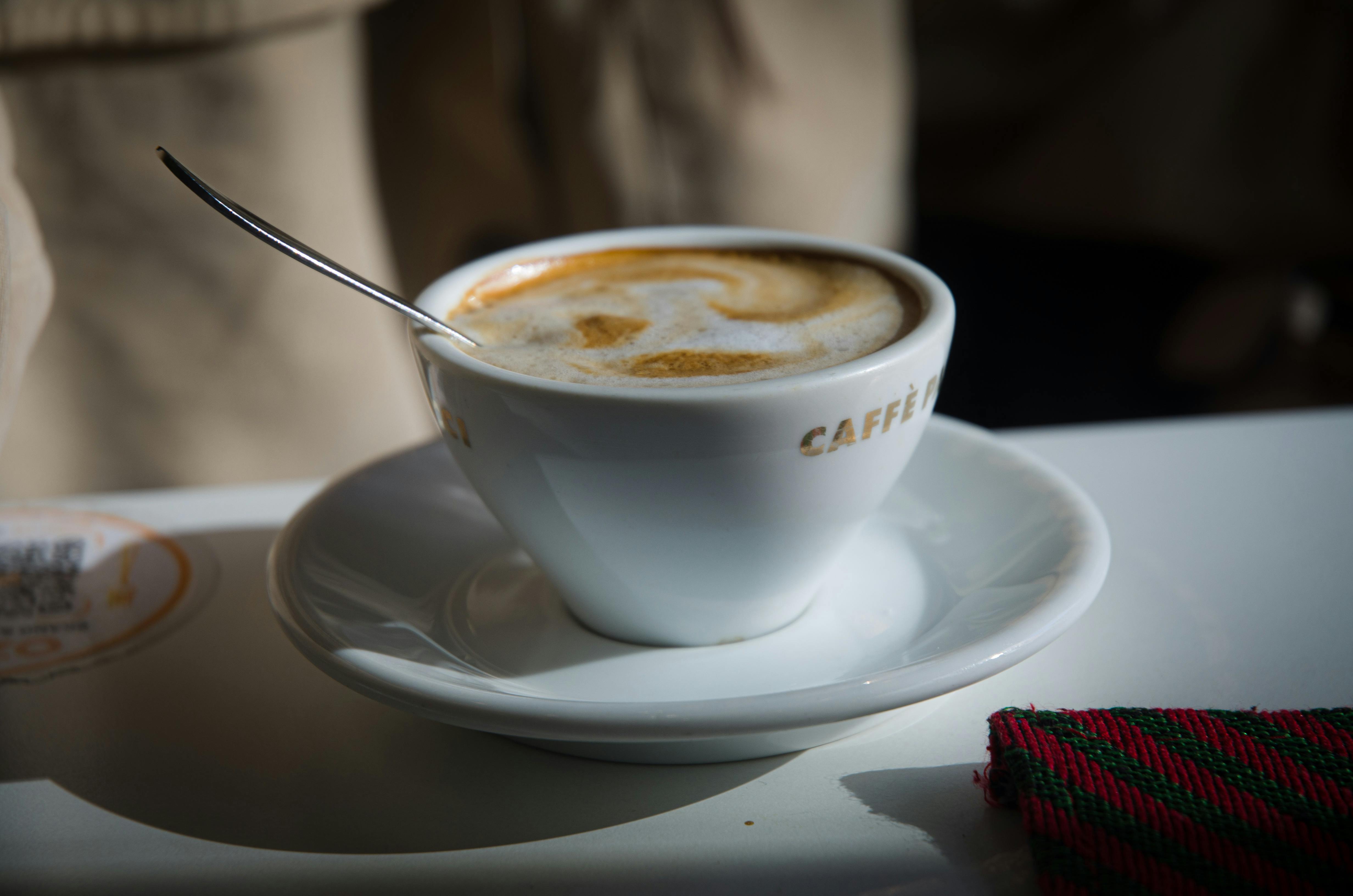 Closeup of a Cup of Coffee near the Books · Free Stock Photo