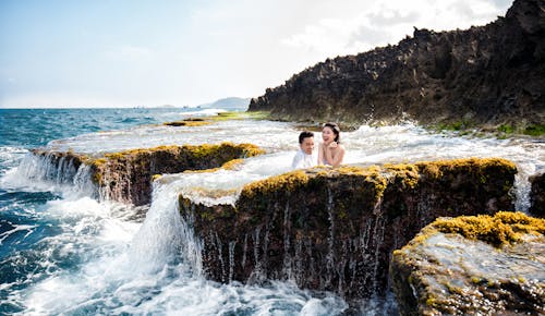 Man and Woman on a Rocky Waterfall Shore 